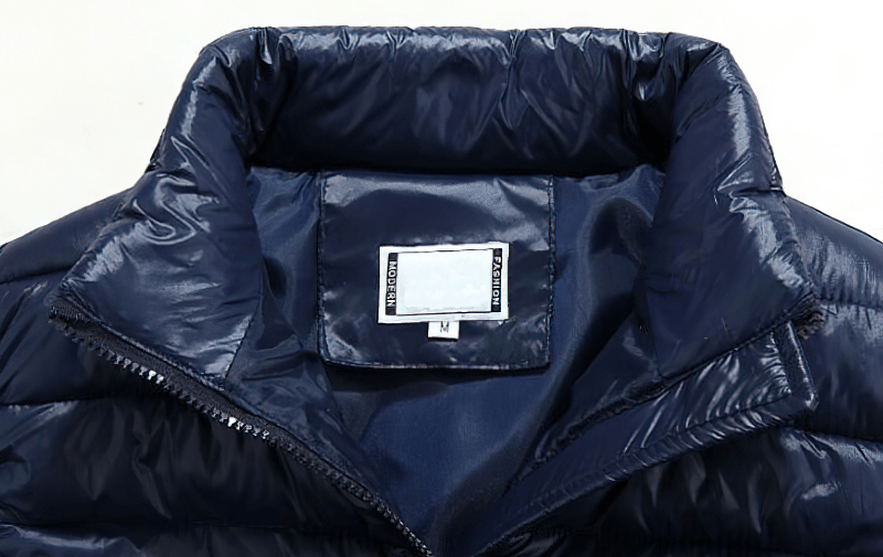 Close-up of navy thermal vest with mandarin collar, showcasing zipper and tag inside. Casual, warm, sleeveless design for women.